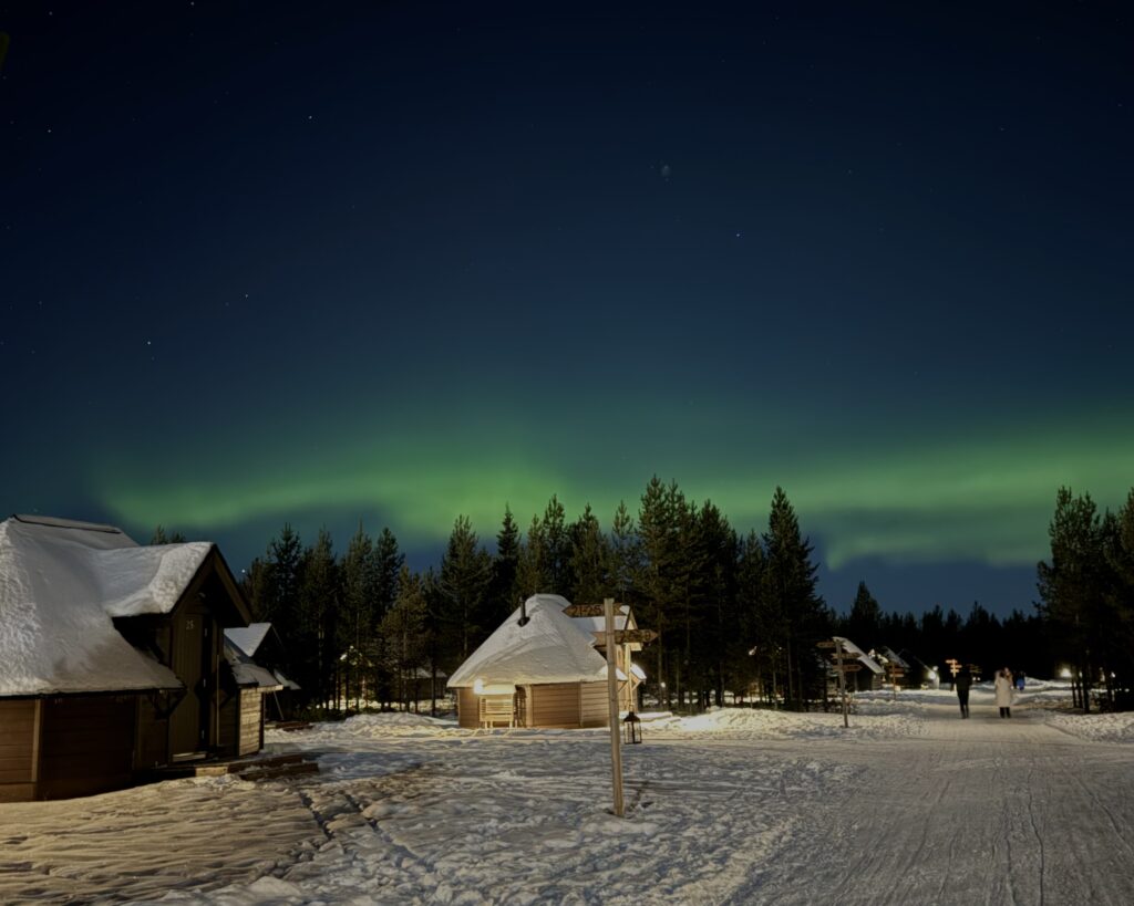northern light over finland houses in snow