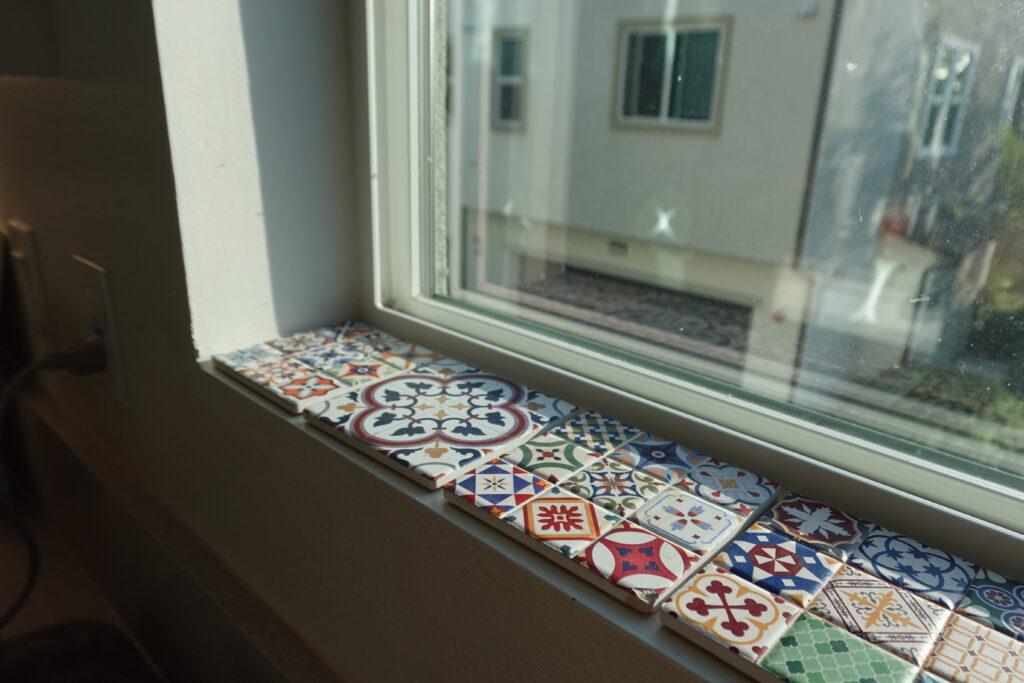 white window sill with Spanish peel and stick tiles