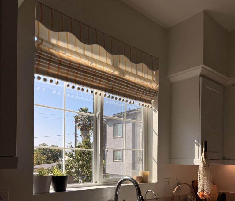 warm golden afternoon light coming through a yellow striped Roman shade