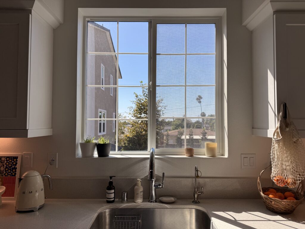 peel and stick window grids on a kitchen window with a palm tree view